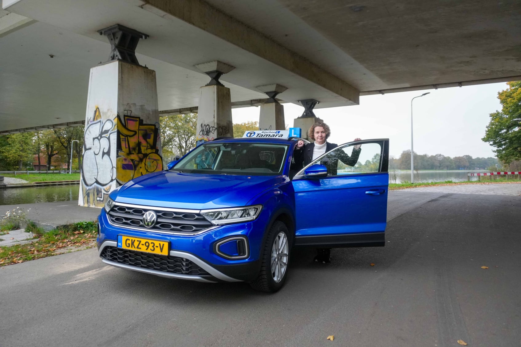 Tamara naast de lesauto